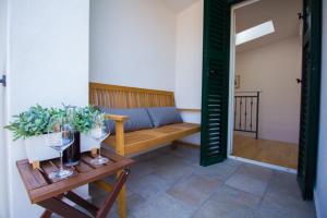 a room with a bench and a table with wine glasses at Apartments Baška in Baška +37 photos
