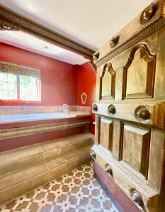 a bathroom with a tub and red walls at The Mill House on the Brooks South Downs West Sussex Sleeps 15 in Hardham