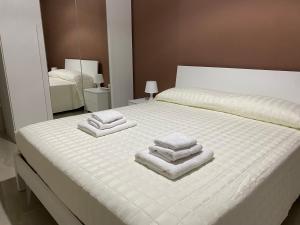 Marconi Rooms and Apartaments في Campobello di Licata: غرفة نوم عليها سرير وفوط