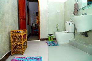 a bathroom with a toilet and a sink and a rug at Dil's Place in Beruwala