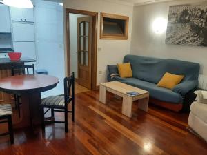 a living room with a blue couch and a table at Coqueto apartamento en el casco viejo in Lekeitio