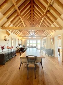 a large dining room with a table and a living room at The Mill House on the Brooks South Downs West Sussex Sleeps 15 in Hardham