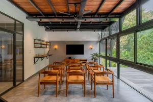 uma sala de conferências com uma mesa longa e cadeiras em K Mansion em Munnar