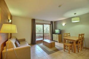 a living room with a couch and a table at SAINTE-FOY STATION - APPARTEMENT 6 PERSONNES - SKIS AUX PIEDS in Sainte-Foy-Tarentaise