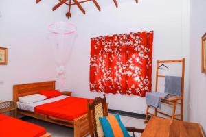 1 dormitorio con cama y manta roja en la pared en Dil's Place en Beruwala