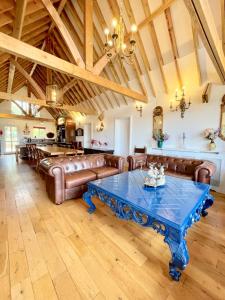 a living room with leather couches and a table at The Mill House on the Brooks South Downs West Sussex Sleeps 15 in Hardham