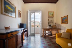 uma sala de estar com uma secretária e uma porta para uma janela em Appartamento La dolce vita em Tropea