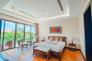Un dormitorio con una cama y una mesa y sillas. en The Ocean Resort, en Da Nang 288 fotos más