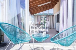 a room with chairs and a table on a balcony at Agios Gordios Ammos House in Agios Gordios