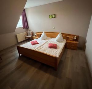 a bedroom with a bed with two red pillows on it at Hotel Vogt in Bad Driburg