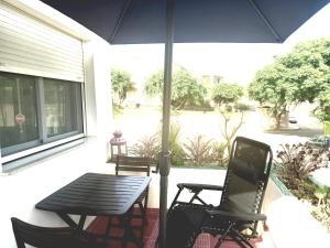 a patio with a table and chairs and an umbrella at Casa Bart de vacaciones in Mazarrón +6 photos