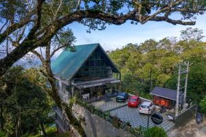 uma vista aérea de uma casa com carros estacionados num parque de estacionamento em K Mansion em Munnar