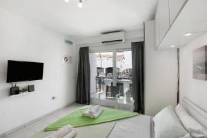 Un dormitorio con una cama y una ventana con un televisor. en Loft Guanapay, en Arona