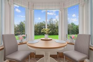 a dining room with a table and two chairs and a window at The Ploughman's Poet in Bathgate