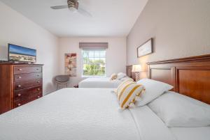 una camera con due letti, un comò e una finestra di Vista Cay Poolside Diamond Near Parks & Walk to OCCC a Orlando