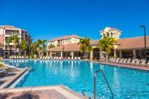 una piscina en un complejo con sillas y palmeras en New! Fantastic Vista Cay Luxury Haven Condo Near all Theme Parks, and walk to Convention Center, en Orlando