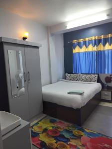 um pequeno quarto com uma cama e um espelho em Hotel Homestay Inn em Thimi