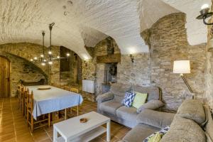ein Wohnzimmer mit einem Sofa und einem Tisch in der Unterkunft Mas Cases in Girona