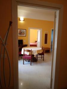 Zimmer mit einem Tisch und Stühlen sowie einem Schlafzimmer in der Unterkunft FORESTERIA DEL TEATRO in Agrigento