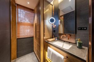 La salle de bains est pourvue d'un lavabo et d'un miroir. dans l'établissement 北京悦明元星空白塔景观四合院民宿, à Pékin