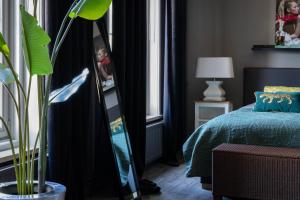 - une chambre avec un lit et un miroir à côté d'une fenêtre dans l'établissement Mart9 City Loft, à Zevenbergen