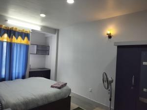 um quarto com uma cama com uma cortina azul e amarela em Hotel Homestay Inn em Thimi