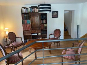 a living room with a table and chairs and bookshelves at chambres de l'étang de la Demoiselle in Saint-Nabord