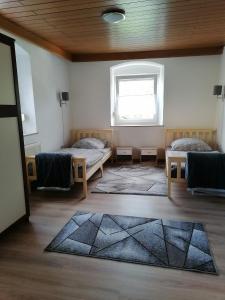 Zimmer mit 2 Betten, einem Fenster und einem Teppich in der Unterkunft Naab-burg in Nabburg