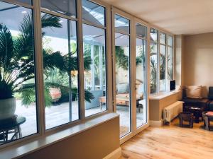um quarto com janelas grandes e uma sala de estar em Les Grands Jardins Lodge em Giverny