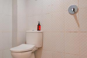 La salle de bains est pourvue de toilettes avec un extincteur rouge. dans l'établissement Urbanview Hotel AVA Banjarmasin by RedDoorz, à Banjarmasin