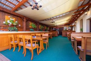 a restaurant with wooden tables and chairs and a bar at Penzión Zemianska kúria in Dolný Kubín