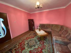 a living room with a couch and a table at Casa- viata la tara in Bucureşci