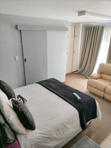 a bedroom with a large bed and a couch at 2 on Haig Accommodation, Selbourne, East London in East London