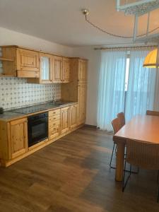een keuken met houten kasten en een tafel en een eetkamer bij Appartamenti Miriam in Passo del Tonale