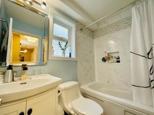a bathroom with a sink and a toilet and a tub at Private Guest Suite in Little Italy - King Bed - Free Parking - Central Location in Vancouver