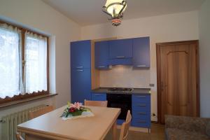 une cuisine avec des armoires bleues et une table dans l'établissement Casa Da Rin Elena, à Auronzo di Cadore