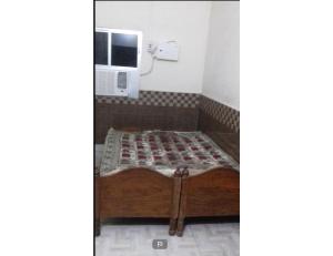 a bed in a room with a computer on the wall at Harkishan Lodge, Sambalpur, Odisha in Sambalpur