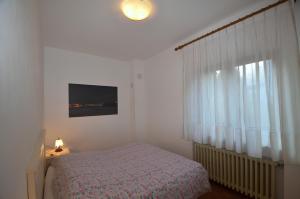 Schlafzimmer mit einem Bett und einem Fenster in der Unterkunft Casa Da Rin Giulia in Auronzo di Cadore