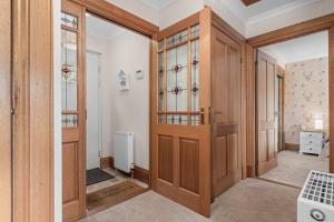 a room with a wooden door and a hallway at The Ploughman's Poet in Bathgate