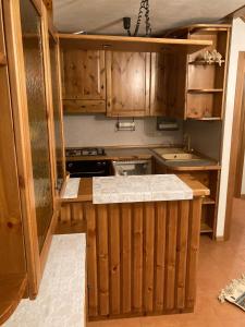 een keuken met houten kasten en een aanrecht bij Appartamenti Miriam in Passo del Tonale