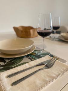 stół z lampką wina oraz widelcem i nożem w obiekcie Casa Gaeta w mieście Gaeta