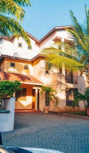 un edificio con palmeras delante en Home away from home, 5 Bedroom Villa, Bustani Close, Nyali Beach, en Mombasa