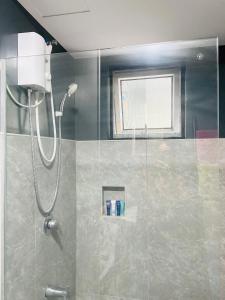 W łazience znajduje się prysznic ze szklanymi drzwiami. w obiekcie Modern Living at Avida Riala w Cebu