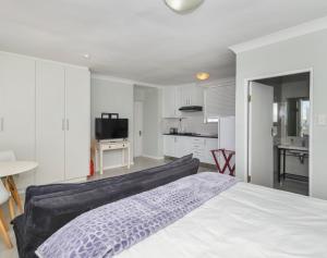 a bedroom with a large bed and a kitchen at Ocean Way Villas - Self Catering in Cape Town