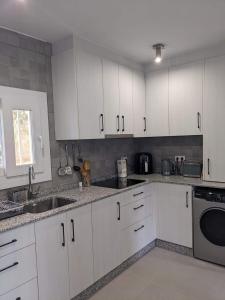 a kitchen with white cabinets and a sink at Buena Vista Golf, Ciudad Quesada in Ciudad Quesada