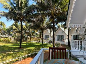 einen Blick vom Balkon eines Hauses mit Palmen in der Unterkunft S2 Beach Cottages in Morjim