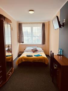 a small bedroom with a bed and a window at Royal House in Białogard