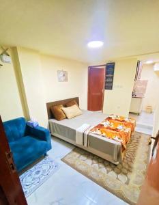 sypialnia z łóżkiem i niebieskim krzesłem w obiekcie King bed-Studio Room Near "al bateen" Abudhabi w Abu Zabi