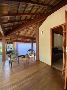 Quinta do Sossego في ماتا دي ساو جواو: غرفة معيشة مع طاولة وكراسي على أرضية خشبية