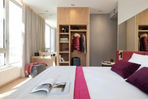 a bedroom with a bed with a book on it at Hôtel Alhena in Flaine